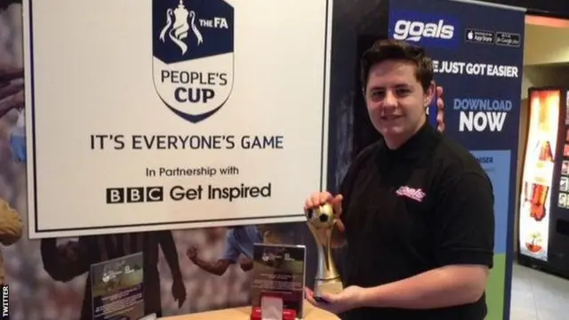 Young guy holding a People's Cup trophy