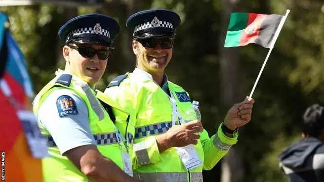 A policeman waves an Afghanistan flag