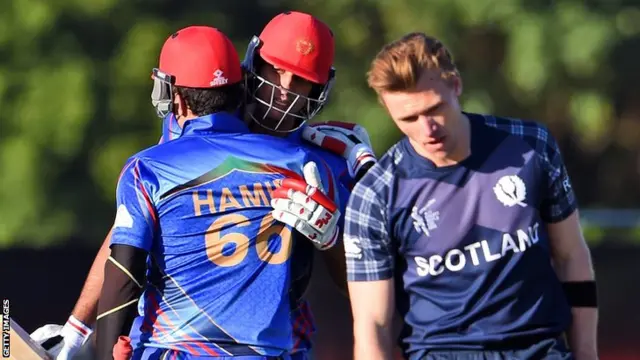 Afghanistan batsmen Hamid Hassan (left) and Shapoor Zadran (centre) celebrate as Scotland"s Richie Berrington (right) reacts