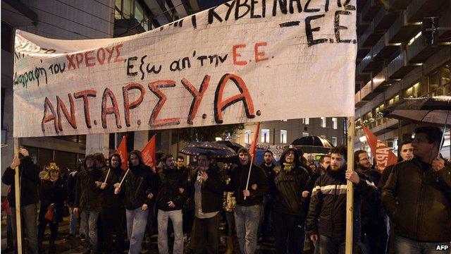 People carry banner reading "out of EU" and "cancel the debt" during a demonstration in Athens on 26 February 26
