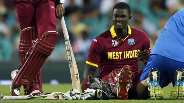 Jason Holder (sat) receives treatment