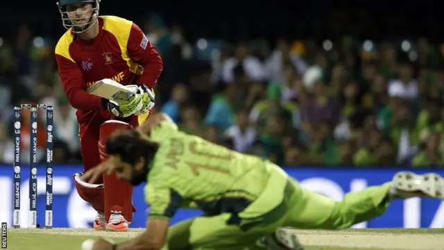 Brendan Taylor sees his drive stopped by Shahid Afridi