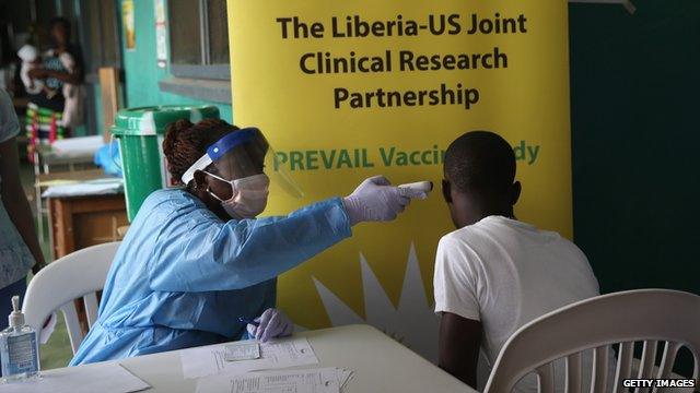 A nurse takes the temperature of a volunteer in the Ebola vaccine trials on 2 February, 2015 in Monrovia, Liberia