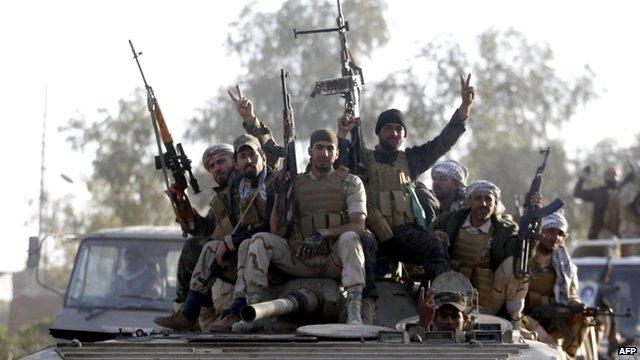 Iraqi security forces and Shiite fighters sit on a tank in the Salahuddin province 2 March, 2015