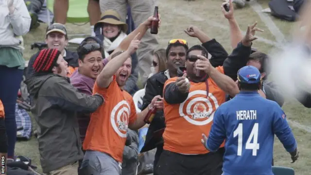 A fan takes a catch in the crowd at the opening game of the tournament