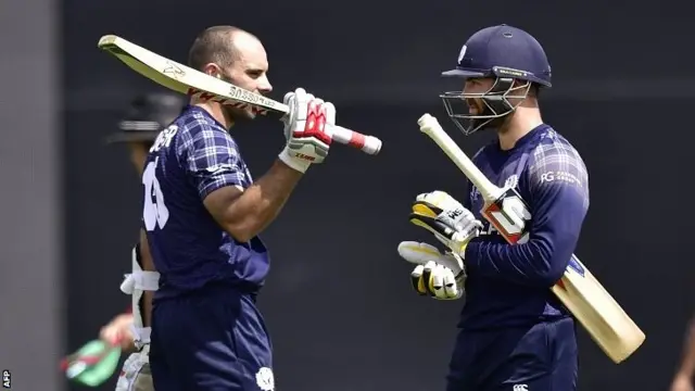 Scotland batsman Kyle Coetzer (L) celebrates a century with captain Preston Mommsen