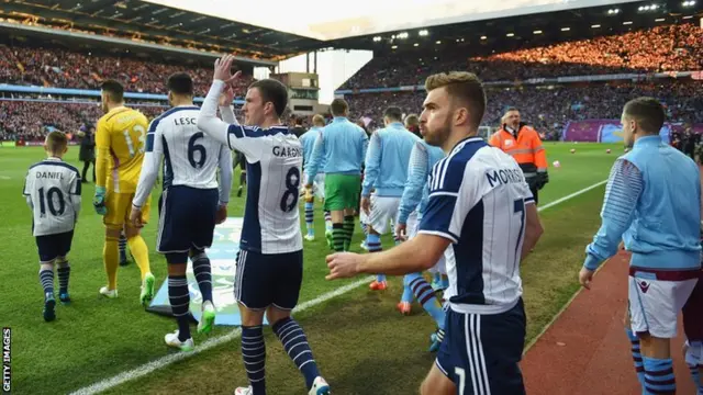 Players walk out onto the pitch