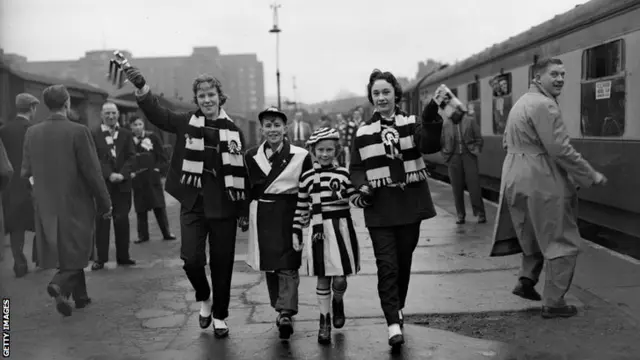 Football fans catch a train in 1957