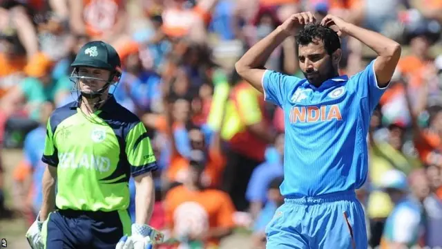 India's Mohammed Shami, right, reacts after bowling as Irelan's William Portfield watches