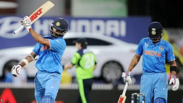 Shikhar Dhawan, left, swings his bat as he leaves the field