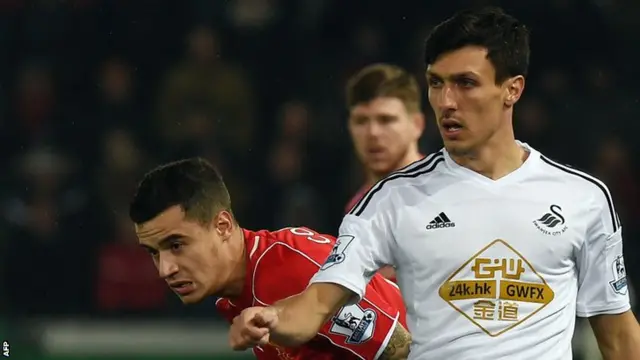 Swansea's Jack Cork holds off Philippe Coutinho
