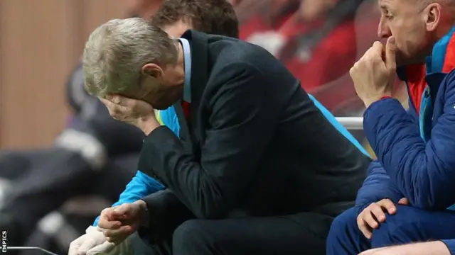 Arsene Wenger holds his head in his hands