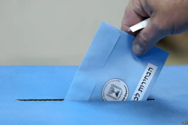 An Israeli drops his ballot into the ballot box as he votes in the Israeli general elections in a school polling station in Tel Aviv, Israel, 17 March 2015.