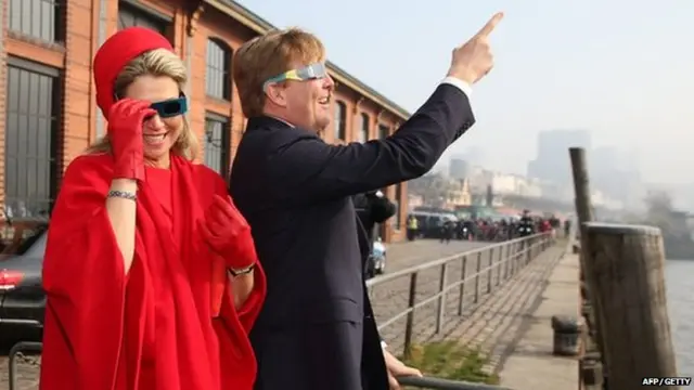 King Willem-Alexander of the Netherlands and Queen Maxima of the Netherlands use protective glasses to watch a solar eclipse.