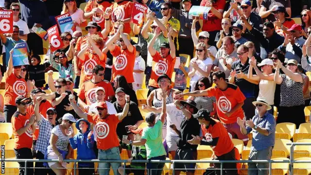 A fan celebrates catching the ball