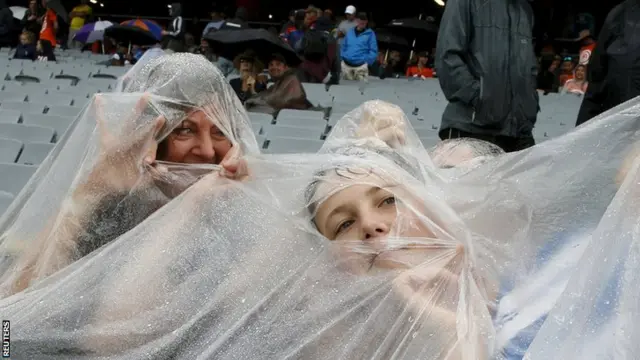 Fans under rain macs at the cricket