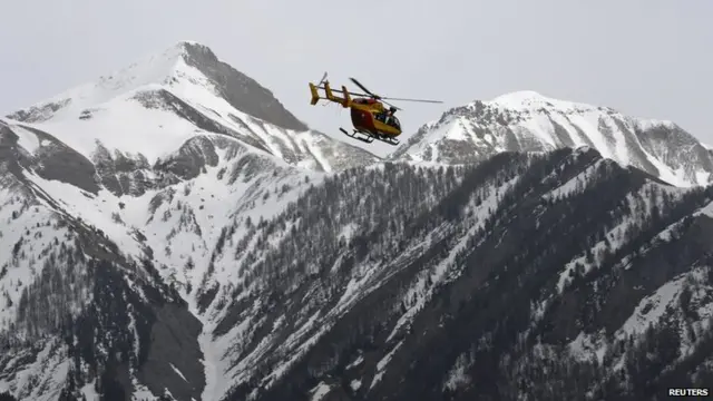 A rescue helicopter flies over the French Alps during a operation after the crash of an Airbus A320