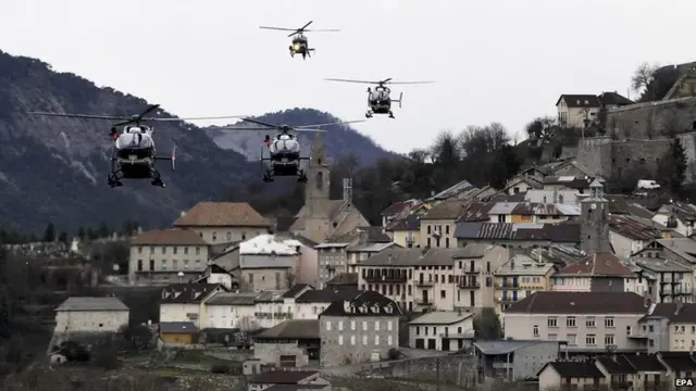 Rescue helicopters fly over Seyne-les-Alpes on 25 March