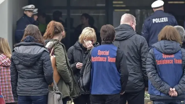 Students, teachers and relatives mourn in front of a school in Haltern, western Germany