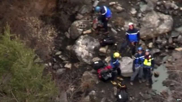 shows search and rescue personnel making their way through the crash site of the Germanwings Airbus A320