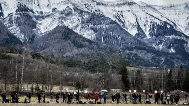 Journalists stand in Seyne, south-eastern France, on March 25, 2015, near the site of the crash of a Germanwings Airbus that slammed into the side of a mountain in the Alps killing the 150 passengers