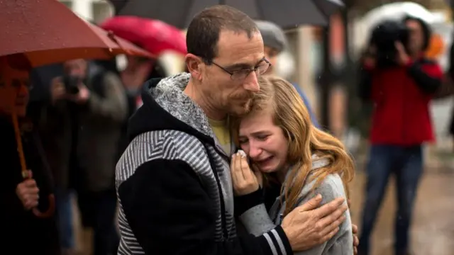 A student who knew some of the German students involved in a crashed plane, reacts during a minute of silence in front of the council building in Llinars del Valles, near Barcelona, Spain