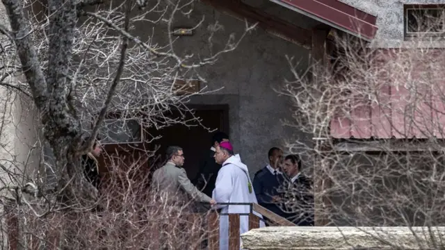 A priest prepares to greet family members