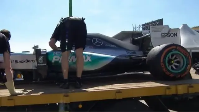 Mercedes mechanics look at Lewis Hamilton's car