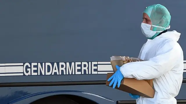 A police officer carries DNA samples of victims of the Germanwings air crash to be tested at a mobile laboratory set up by the gendarmerie on 27 March, 2015