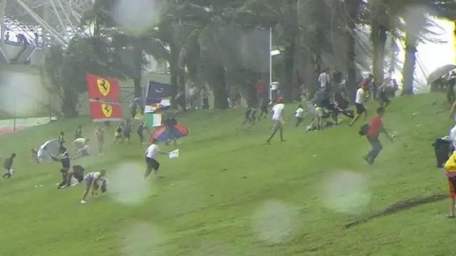 Fans running for cover as the rain falls at the Malaysian Grand Prix