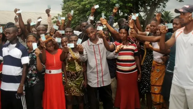 Voters show their cards, ahead of the vote for the presidential elections in Gokana on 28 March 2015
