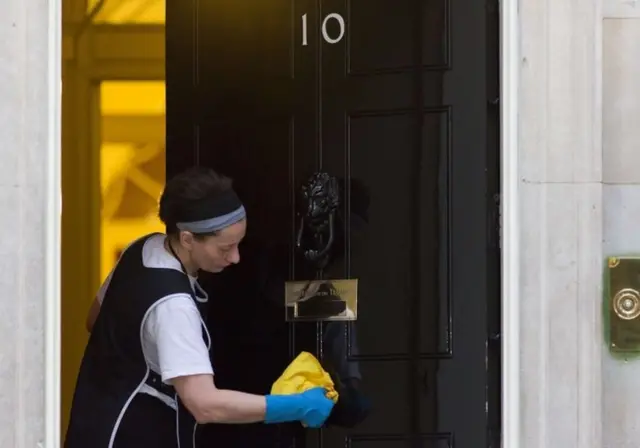 Woman polishes door at No 10