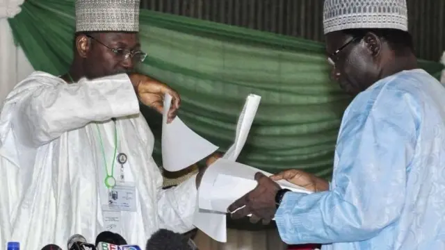 Nigerian Independent National Electoral Commission (Inec) officer for Ondo State, Professor Olusola Oyewole (R) hands over the result sheet of presidential elections in Ondo State to Inec Chairman, to Inec head Attahiru Jega (L) at the national collation centre in Abuja, Nigeria, 30 March 2015