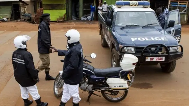 Police stand guard at the scene where acting assistant director of public prosecution Joan Kagezi was shot dead in a suburb in Kampala, on 31 March 2015