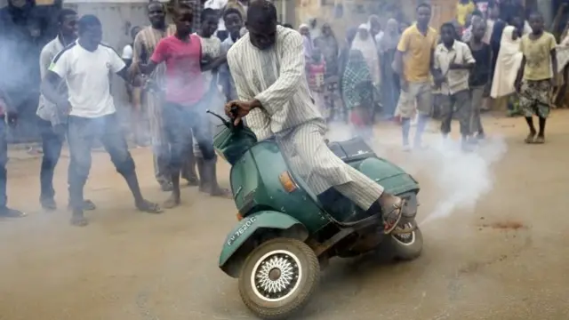 Nigerians celebrate the anticipated victory of Presidential candidate Muhammadu Buhari by doing a burnout on a scooter in Kaduna, Nigeria Tuesday 31 March 2015