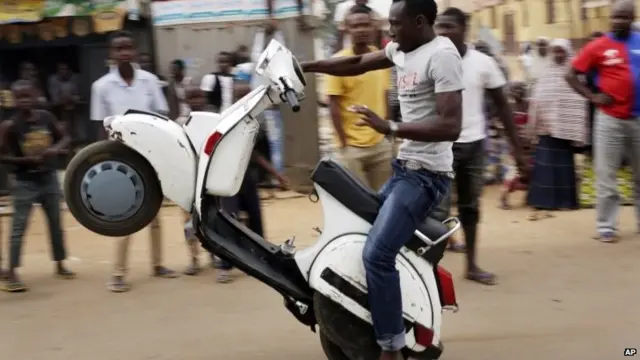 Nigerians celebrate the anticipated victory of Presidential candidate Muhammadu Buhari on a scooter in Kaduna, Nigeria Tuesday 31 March 2015