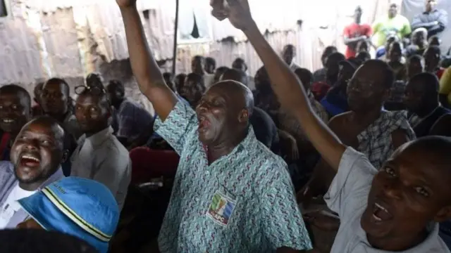 People react as partial results of the Nigerian presidential elections are released by Inec indicating the main opposition All Progressives Congress (APC) presidential candidate is ahead at a public viewing centre in Lagos on 31 March 2015