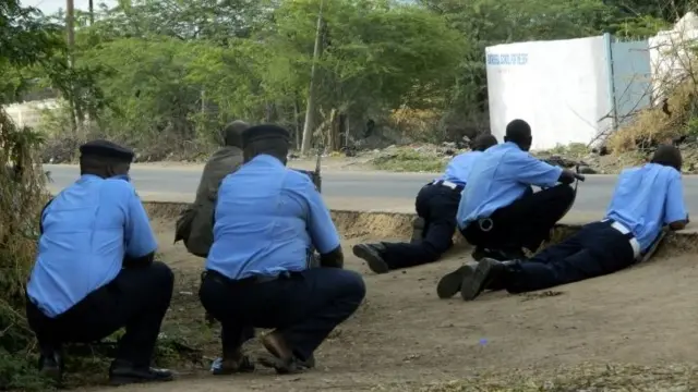 Kenyan police officers take cover outside the Garissa University College during an attack by gunmen in Garissa, Kenya, Thursday 2 April 2015