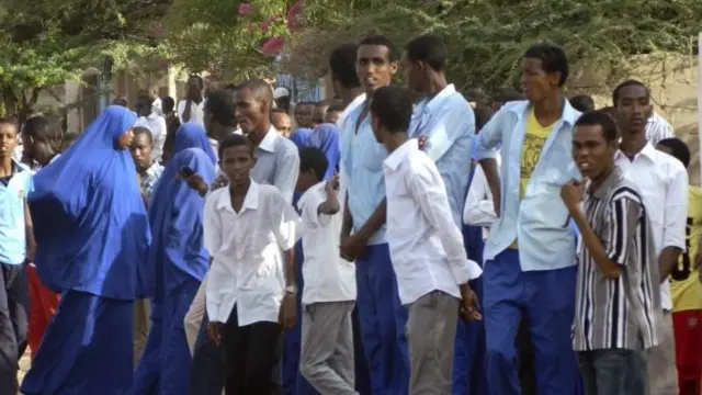 Students gather and watch from a distance outside the Garissa University College after an attack by gunmen in Garissa, Kenya