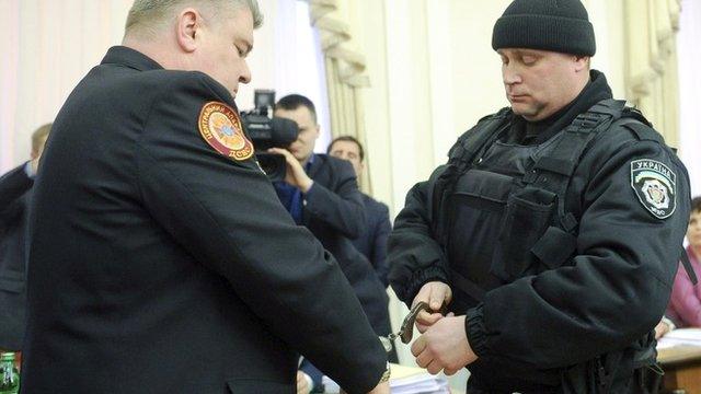 A policeman putting handcuffs on Sergiy Bochkovsky