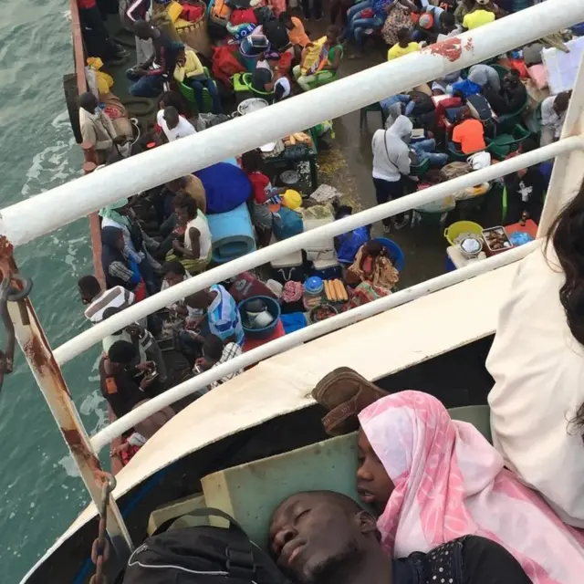 Two young men sleep on a ferry travelling to Bissau from Bubaque Island after the last day of Festival de Bubaque.