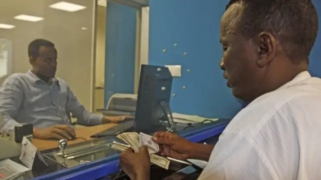 A Somali man counts the money he collected from a money-transfer service in Mogadishu, Somalia - Wednesday 8 April 2015