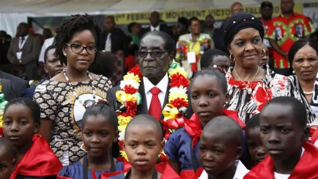 Zimbabwean President Robert Mugabe (C) flanked by his daughter Bona (L) and his wife Grace (R) stand with some of the children who share the same birthday with him at the Elephant Hills Hotel in Victoria Falls, Zimbabwe, 28 February 2015