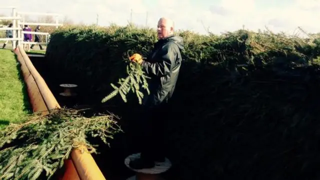 Aintree staff prepare the fences ahead of the Grand National