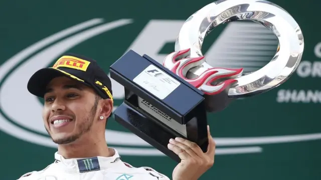 Lewis Hamilton lifts his trophy after victory at the Chinese Grand Prix