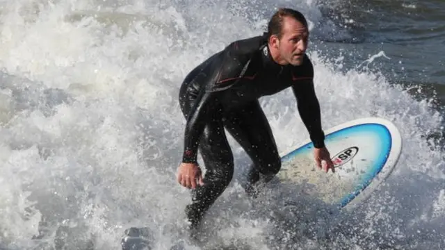 A surfer catches the waves at Bournemouth