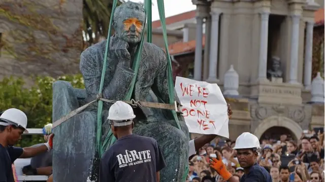 Students surround the decades old bronze statue of British colonialist Cecil John Rhodes, as it is removed from the campus at the Cape Town University