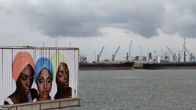 A sign for cosmetic products is seen in front of ships lined up at the Apapa port in Lagos, Nigeria, 11 April 2015