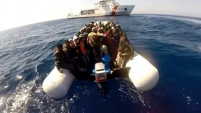 Migrants sit in a boat during a rescue operation on April 15, 2015 off the coast of Sicily as part of the Triton plan