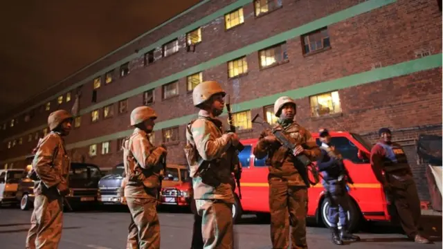 Members of the South African Defence Force mobilize outside the Jeppe Hostel in Johannesburg, South Africa, on 21 April 2015